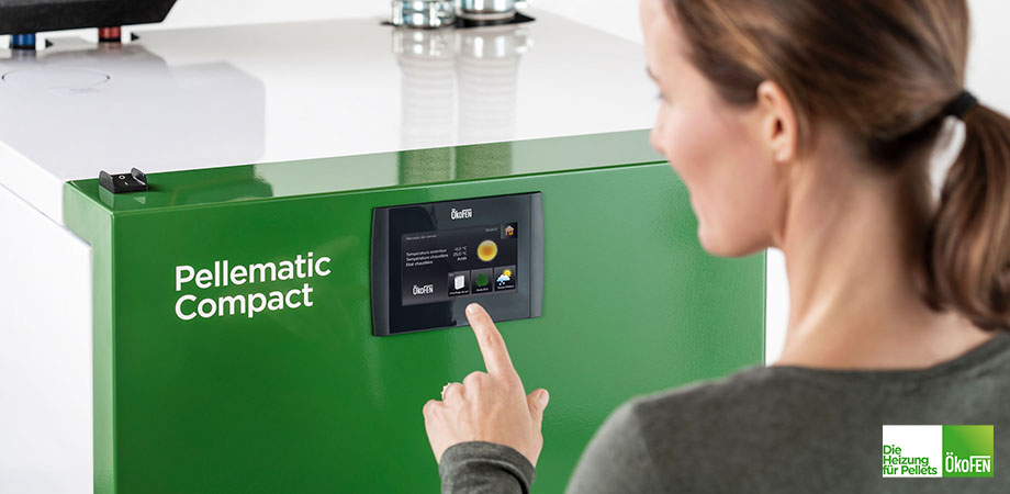 Frau bei der Bedienung einer © Ökofen Pelletheizung